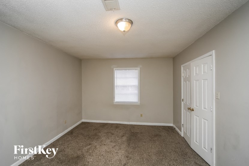 a bedroom with a carpeted floor and a white door