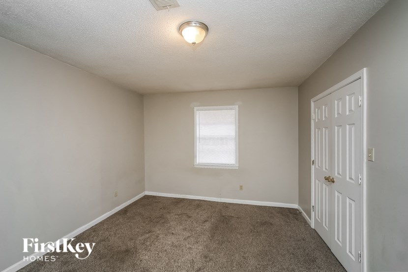 a bedroom with a carpeted floor and a white door