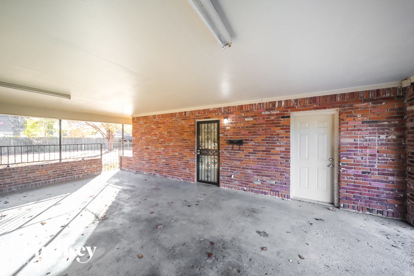 an empty garage with a brick wall and a white door