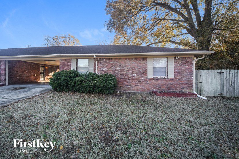 a brick house with a yard in front of it