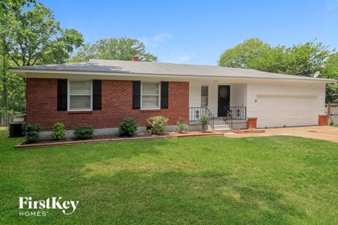 A brick house with a white garage door and a black door.