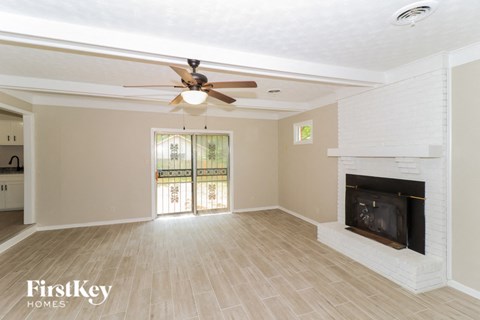 A spacious living room with a fireplace and sliding glass doors.