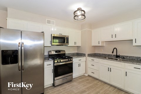 A kitchen with a refrigerator and a microwave.