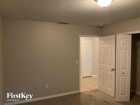 a bedroom with two doors and a closet and a door to the bathroom