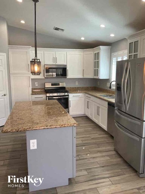 a kitchen with white cabinets and stainless steel appliances