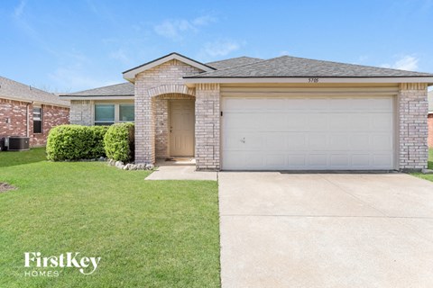 a home with a garage door and a lawn