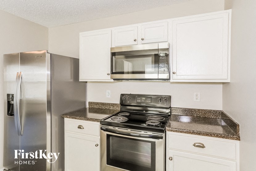 a kitchen with stainless steel appliances and white cabinets