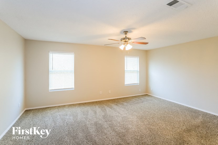 a bedroom with carpet and a ceiling fan