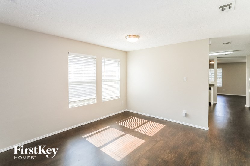an empty living room with white walls and wood floors