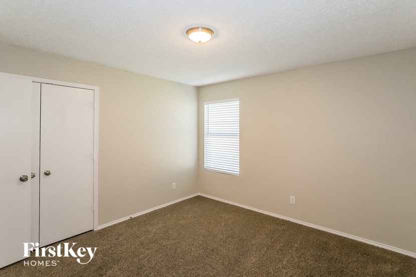 a bedroom with a carpeted floor and a door to a closet