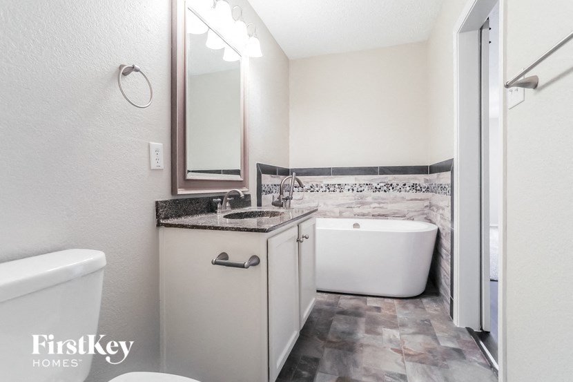 a bathroom with a tub and a sink and a mirror