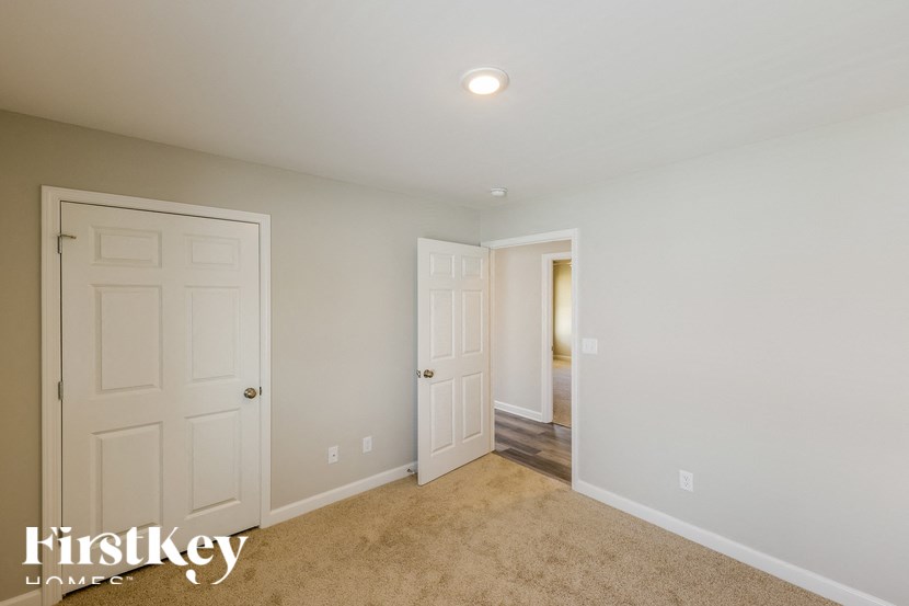 A room with two doors and a carpeted floor.