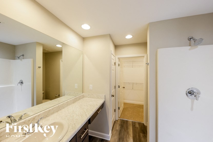 A bathroom with a large white bathtub and a walk-in shower.