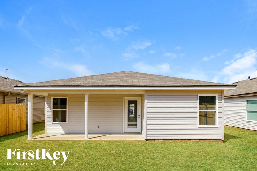 A house with a grey roof and a white wall with a window and a door.