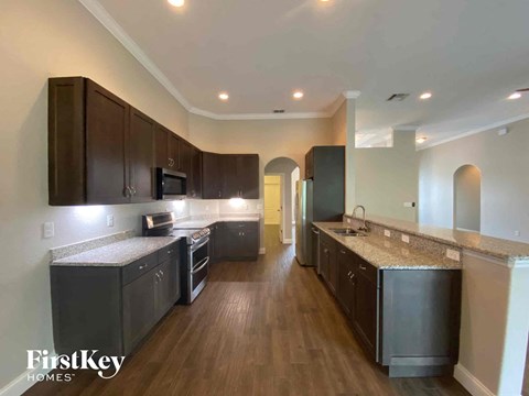 a kitchen with dark wood cabinets and granite counter tops