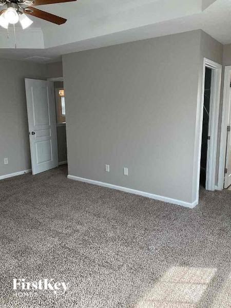 a living room with a white carpet and a ceiling fan