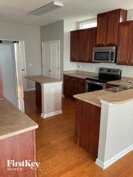 a kitchen with wooden cabinets and a stove and a refrigerator