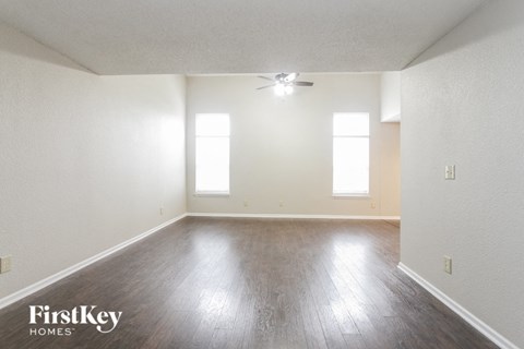 an empty living room with white walls and wood floors