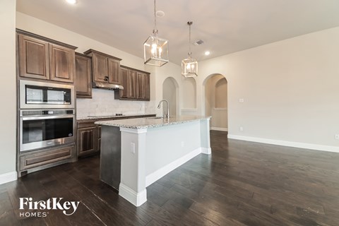 A kitchen with wooden cabinets and a white island.