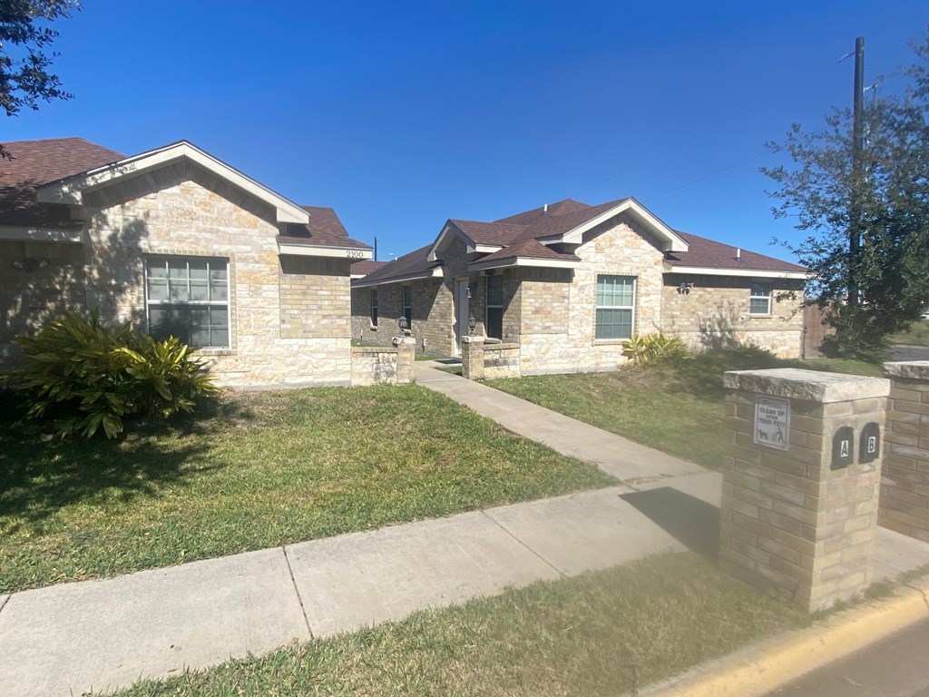 a house in a neighborhood with a sidewalk and grass