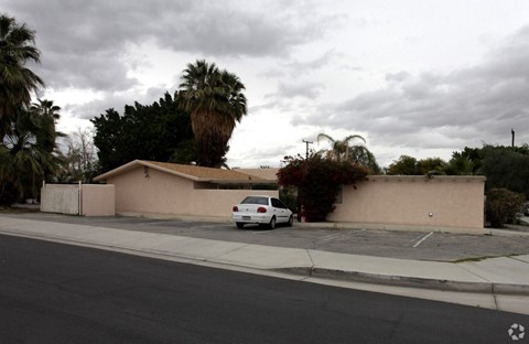 a car parked in front of a house with palm trees