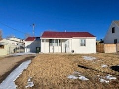 a white house with a red roof on a yard
