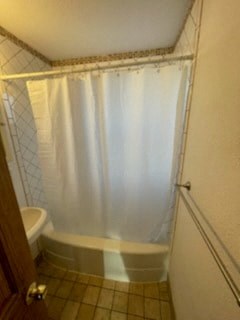 a bathroom with a white shower curtain and a toilet