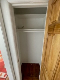 a small closet with a wooden floor and a white door