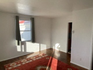 a empty living room with a red rug and a window