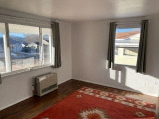 a living room with a red rug and three windows
