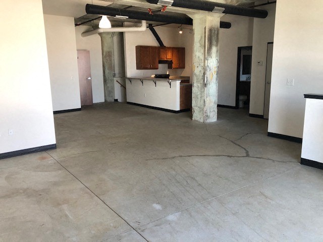 a large empty room with a kitchen in it