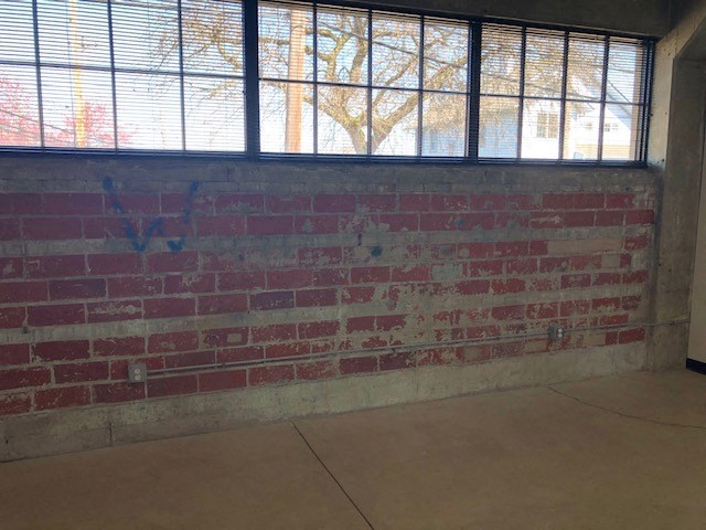a brick wall with graffiti on it in an empty room