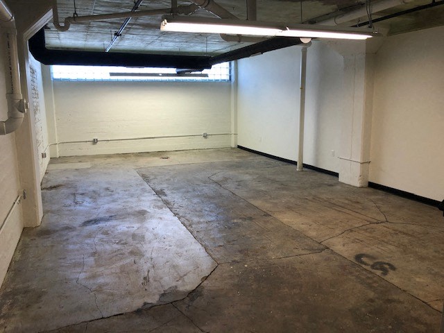 a large room with a concrete floor and white walls