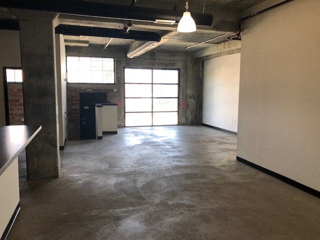 an empty room with a concrete floor and a window