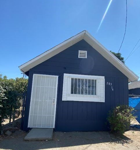 a small blue house with a white window