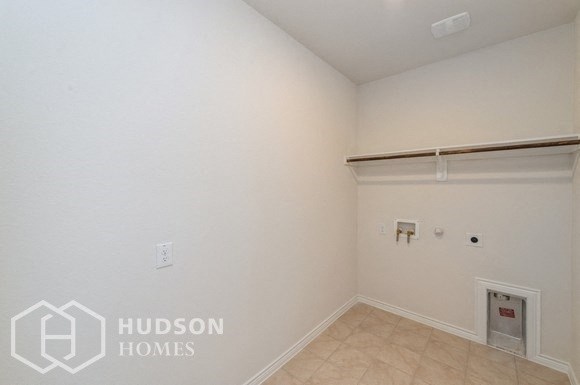 an empty room with a white wall and a large white garage door