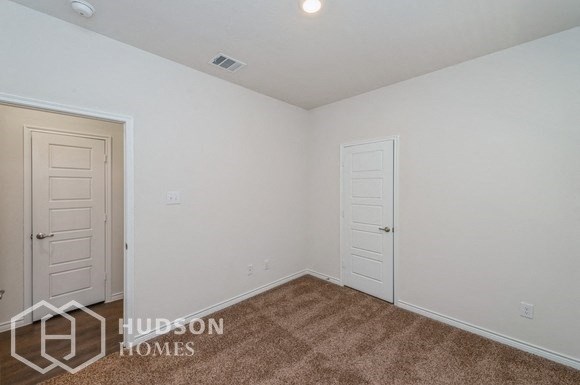 a bedroom with a carpeted floor and two doors