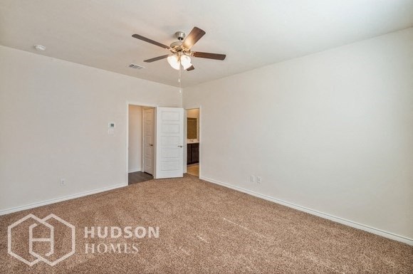 an empty living room with a ceiling fan and white walls