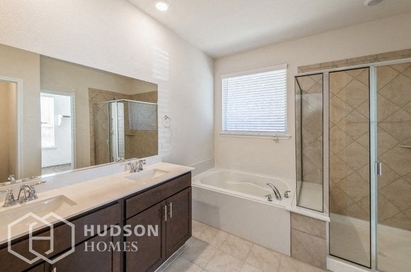 a bathroom with a tub and a sink and a mirror