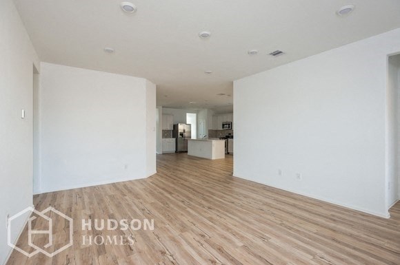 an empty living room with white walls and wood floors