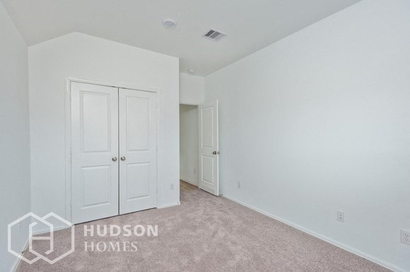 a bedroom with white walls and white doors and carpeting