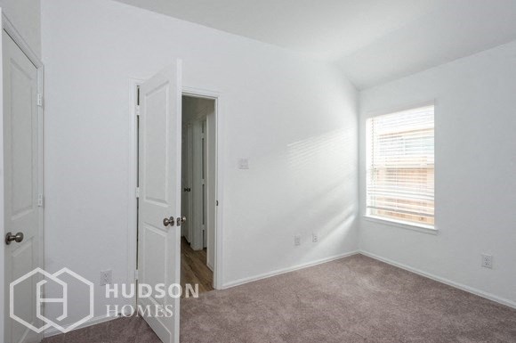 a bedroom with a door to a closet and a window