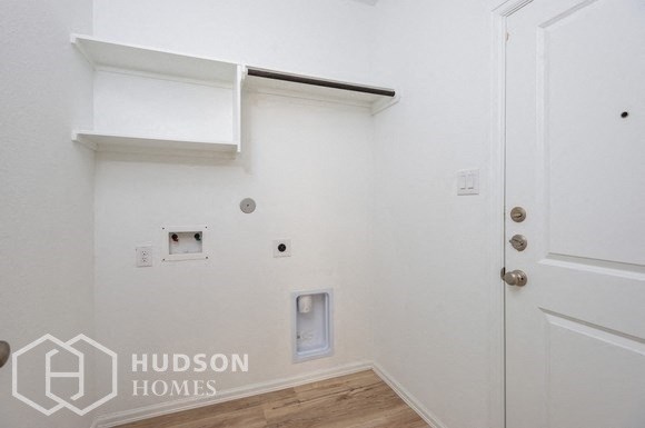 a white walled room with a white door and a white shelf on the wall