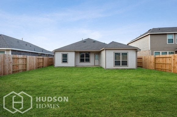 a backyard with a house and a yard and a fence