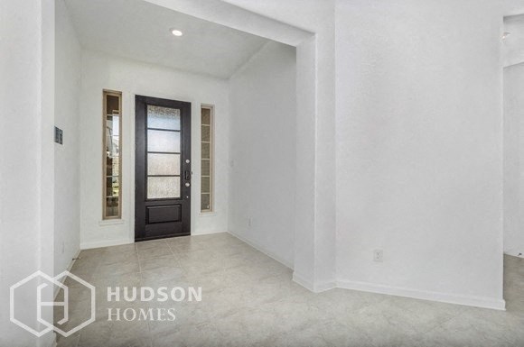 an empty living room with white walls and a black door