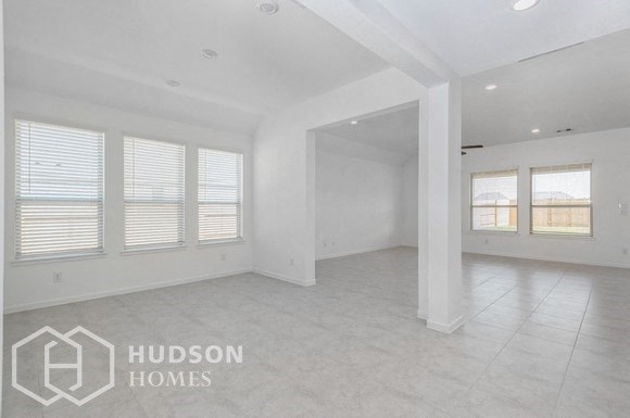 an empty living room with white walls and white tile floors