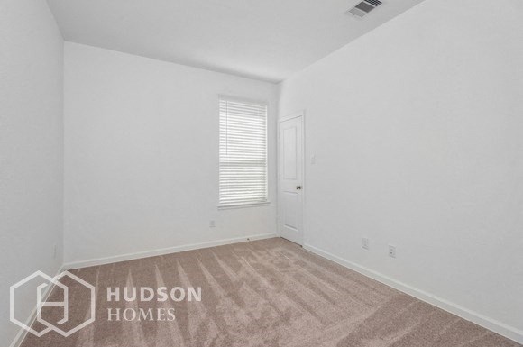 a bedroom with white walls and carpet and a white door
