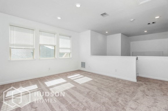 an empty living room with white walls and a large window