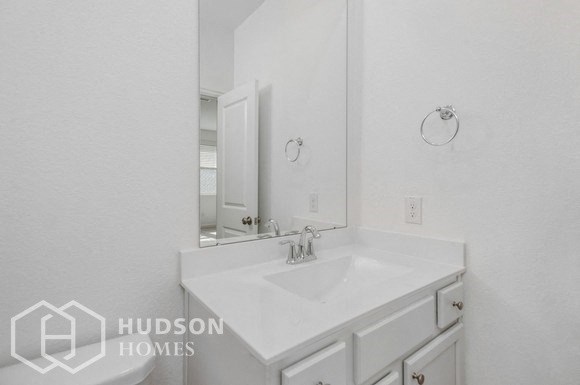 a white bathroom with a sink and a mirror