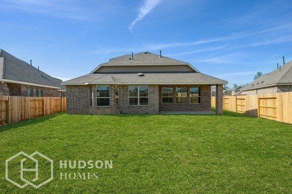 a backyard with a lawn and a house with a fence